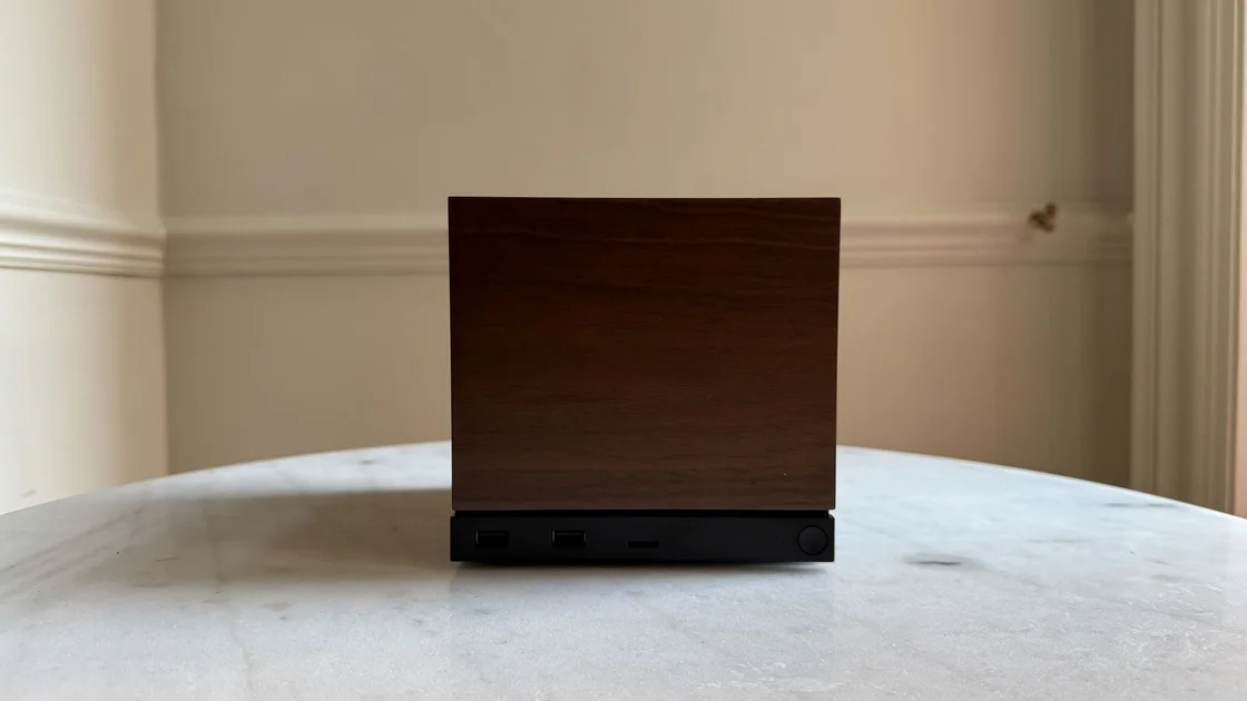 Steam Machine photograph showing the steam machine with wood faceplate on a marble circular table in front of a grey/beige wall
